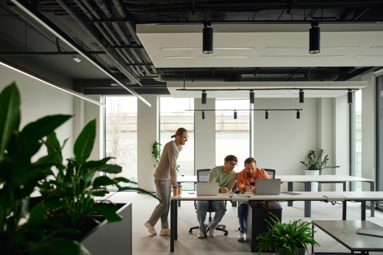 People working in an airy office space with plants.