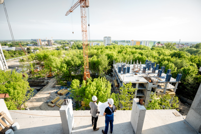 Two people observing a construction site, symbolizing the shift toward performance-focused green building certifications.